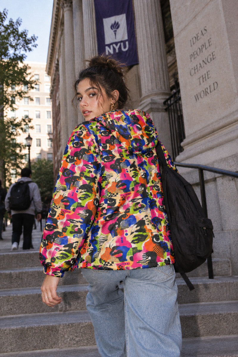 Female Gen Z wearing Face Static colorful windbreaker back view on NYC university campus