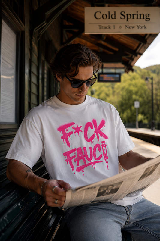 Man wearing white F*CK Fauci graphic T-shirt while reading a newspaper at Cold Spring train station