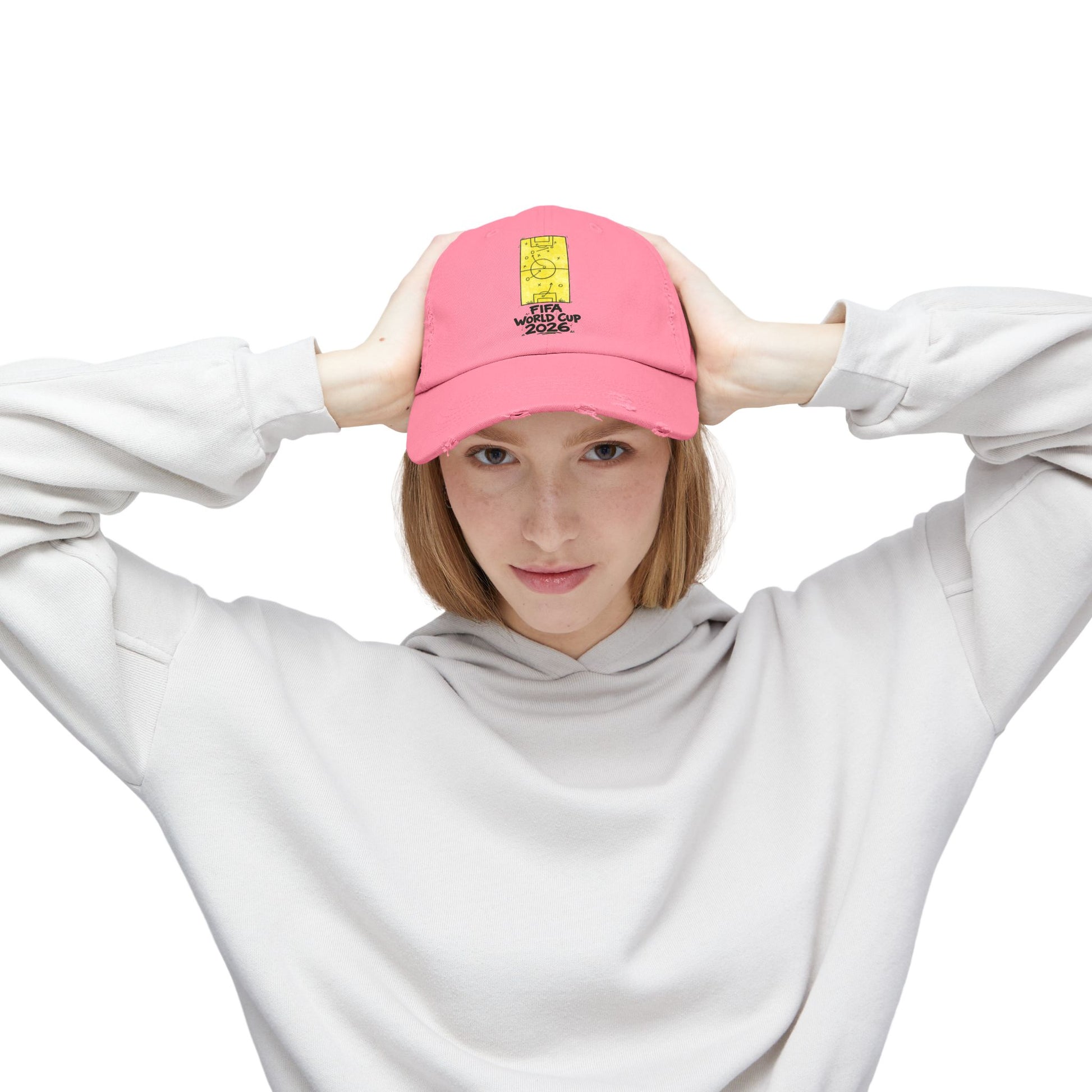 Young woman modeling pink FIFA World Cup 2026 distressed dad hat with oversized hoodie
