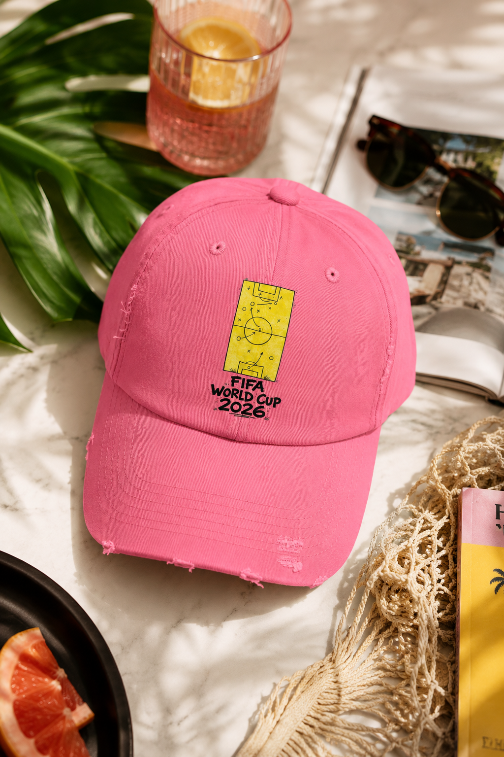 Pink FIFA World Cup 2026 distressed dad hat styled in colorful tropical editorial flat lay photography