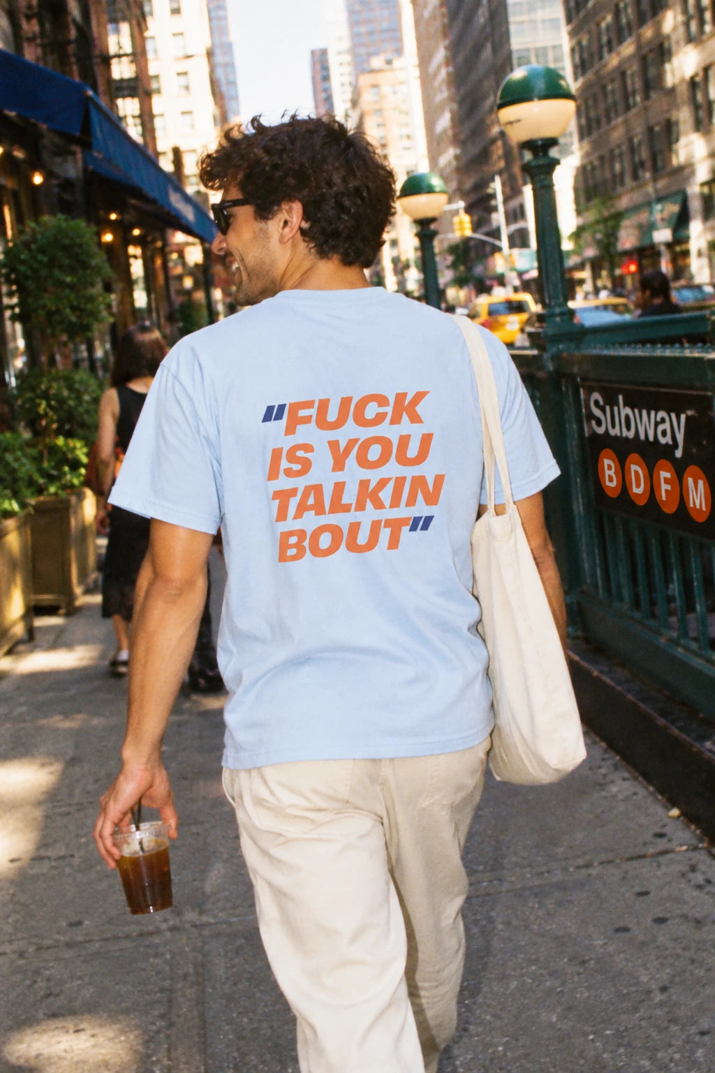 Light blue Fuck Is You Talkin Bout graphic t-shirt worn on a New York City street