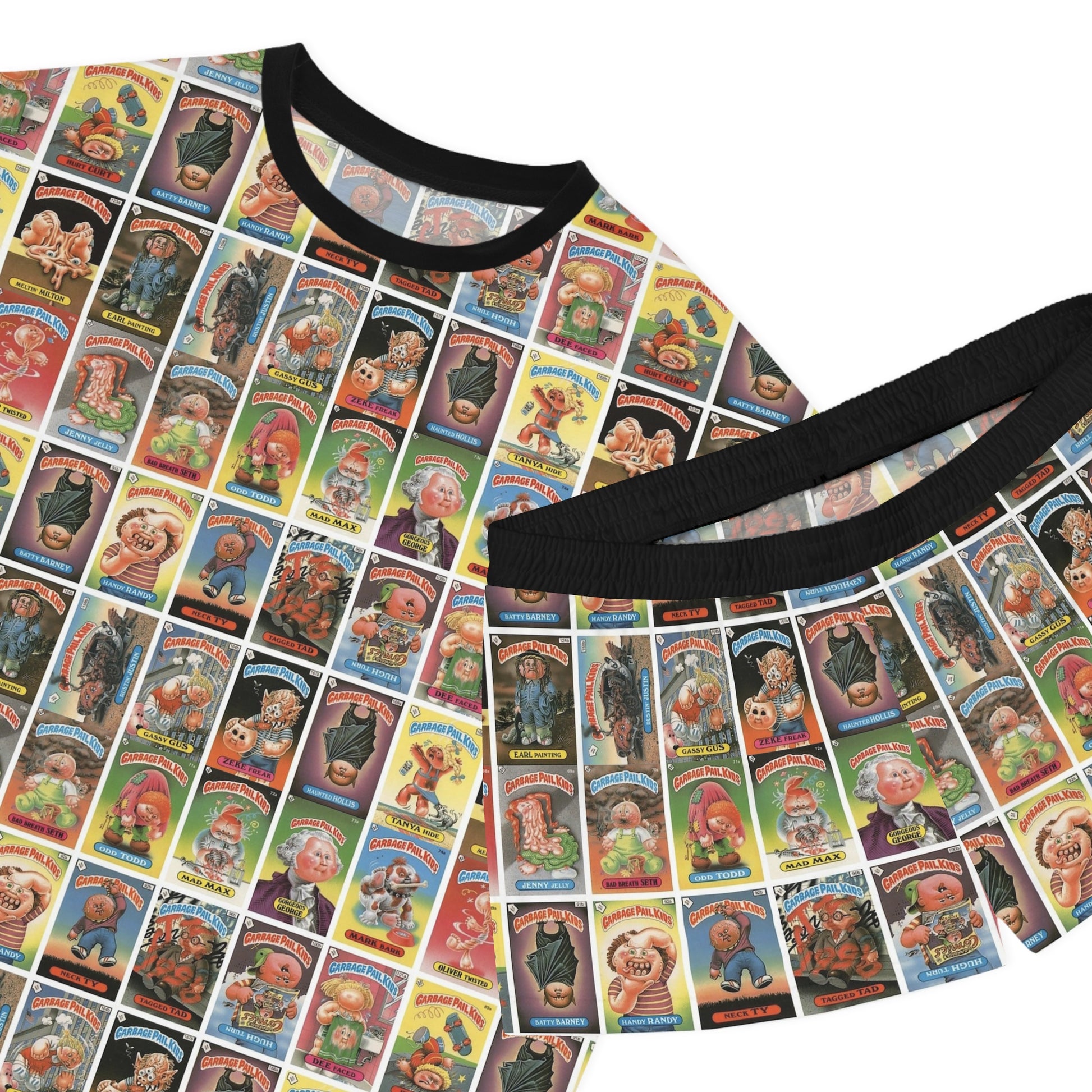 Close-up of Garbage Pail Kids inspired satin pajama set featuring colorful retro trading card collage print and black trim details on matching top and shorts.