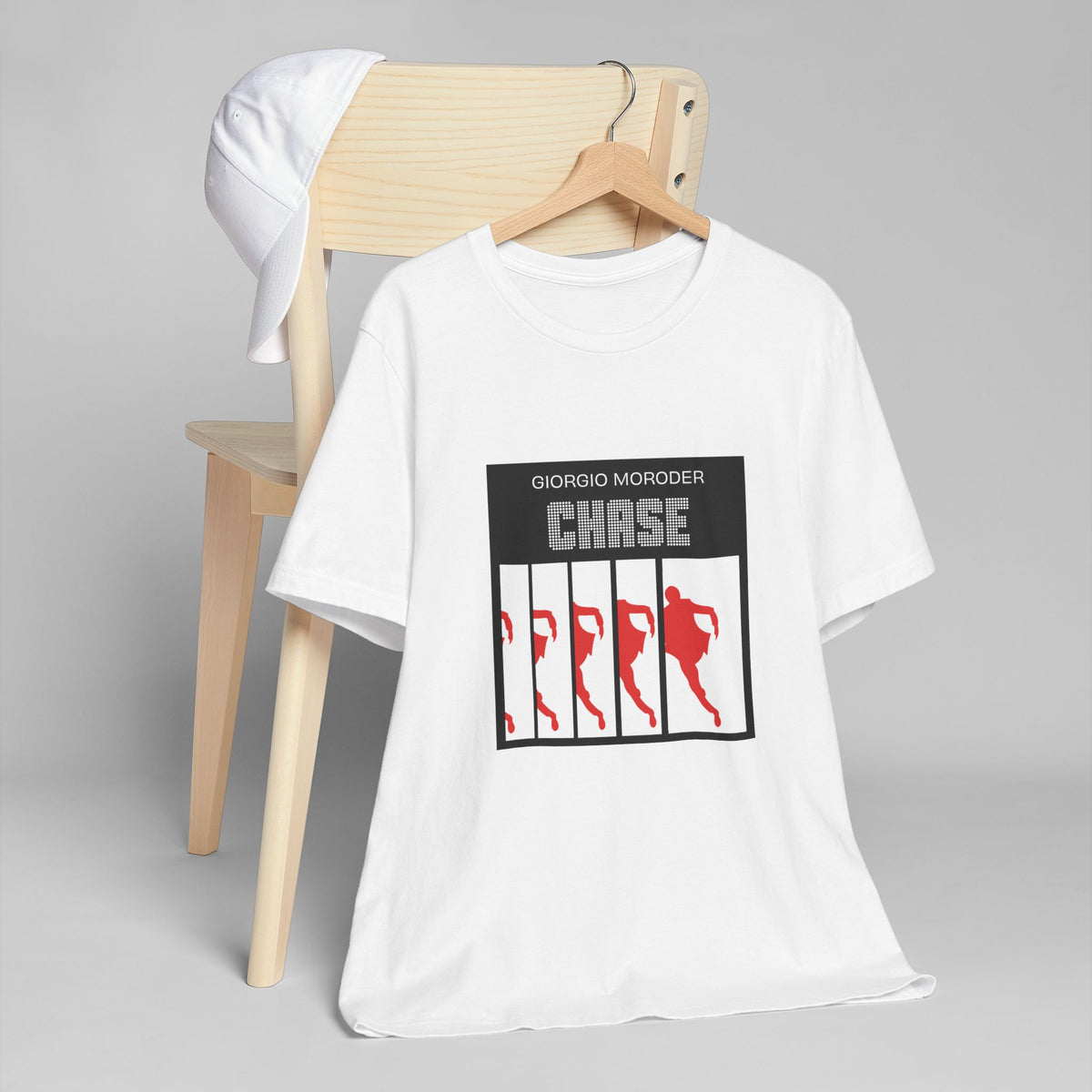 White Giorgio Moroder Chase T-shirt on a wooden hanger, showing the black, white and red single-cover print.