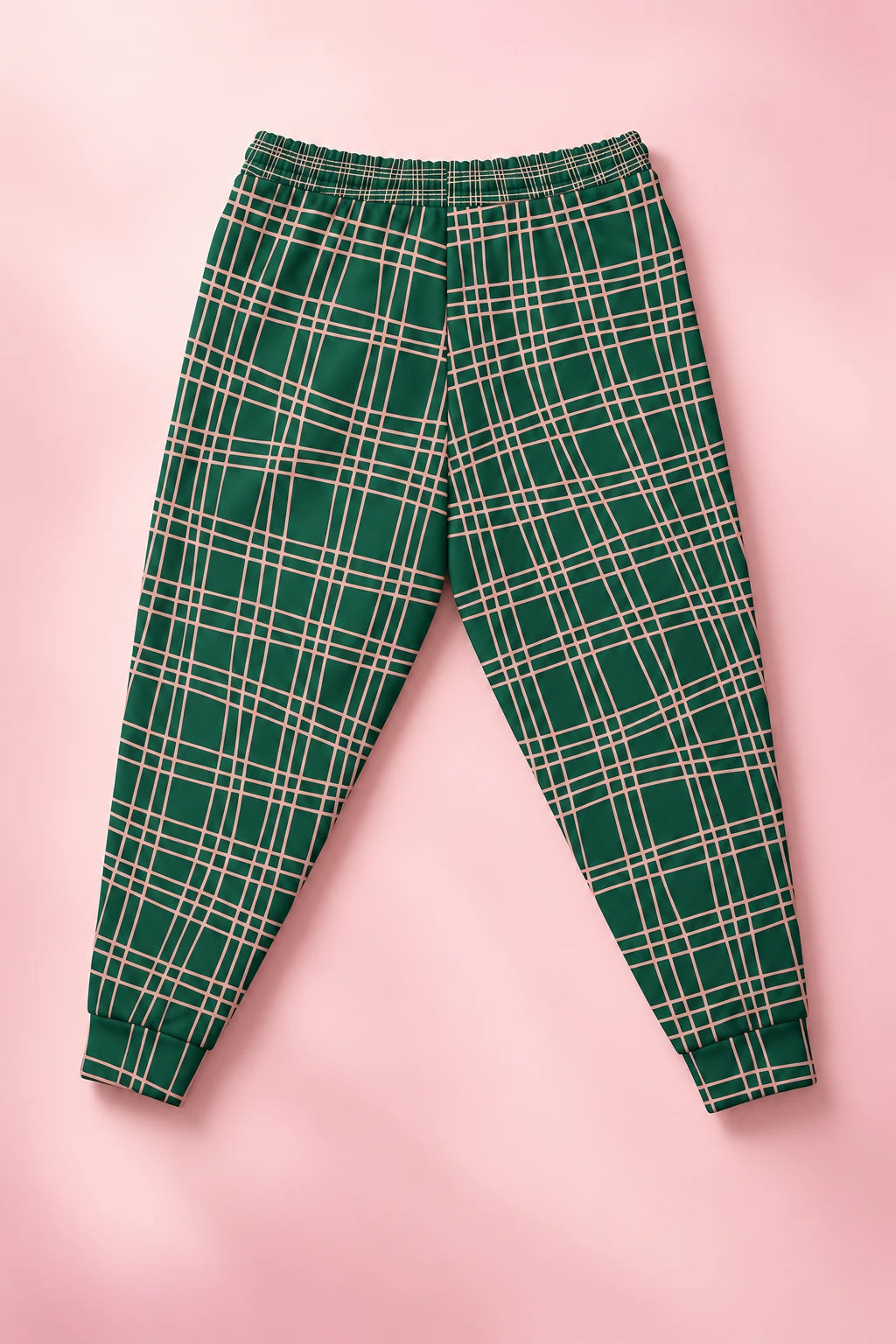 Back flat lay of green and pink plaid joggers on a soft pastel pink background