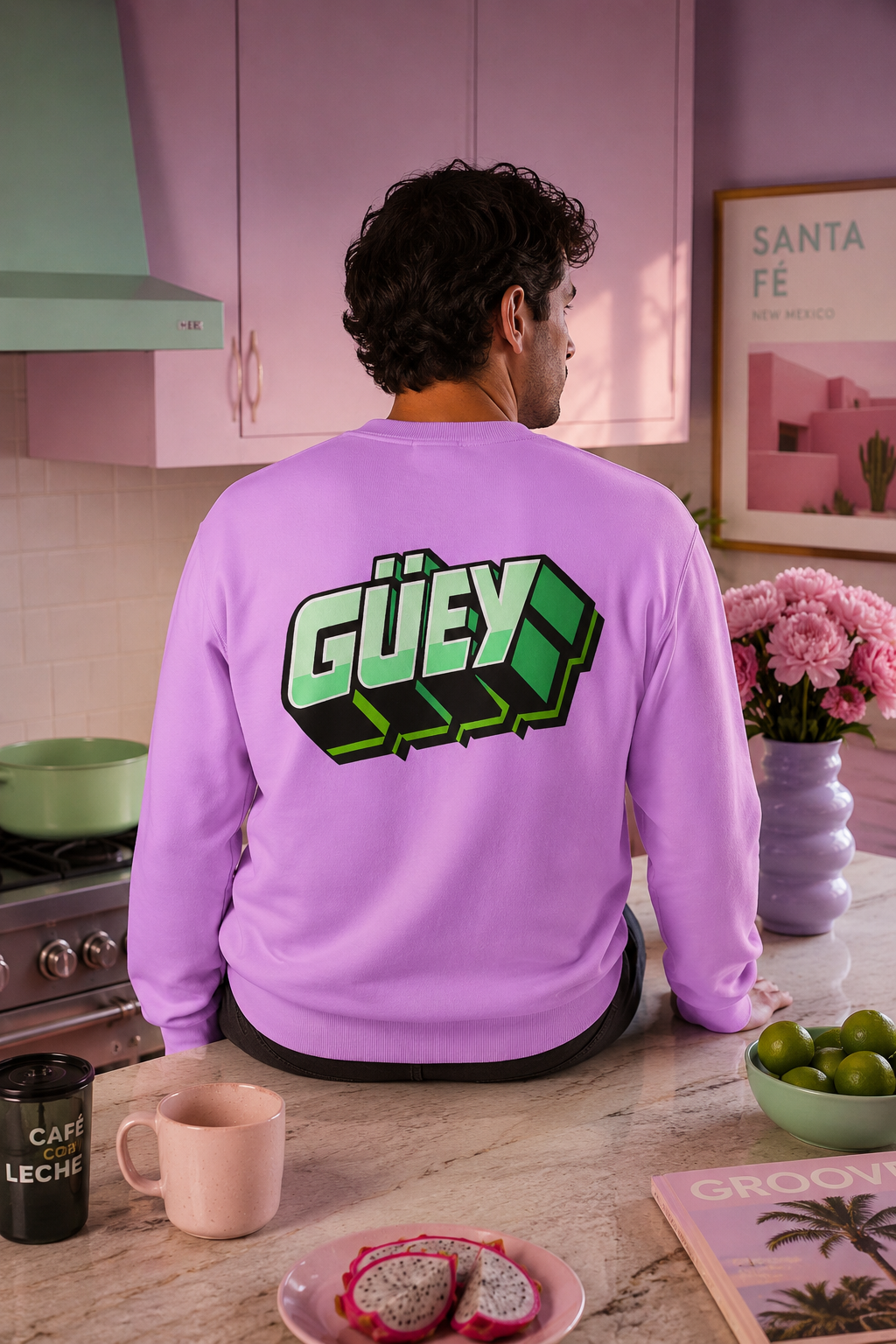 Millennial man wearing a purple Güey Mexican slang sweatshirt while sitting at a colorful kitchen counter, back view