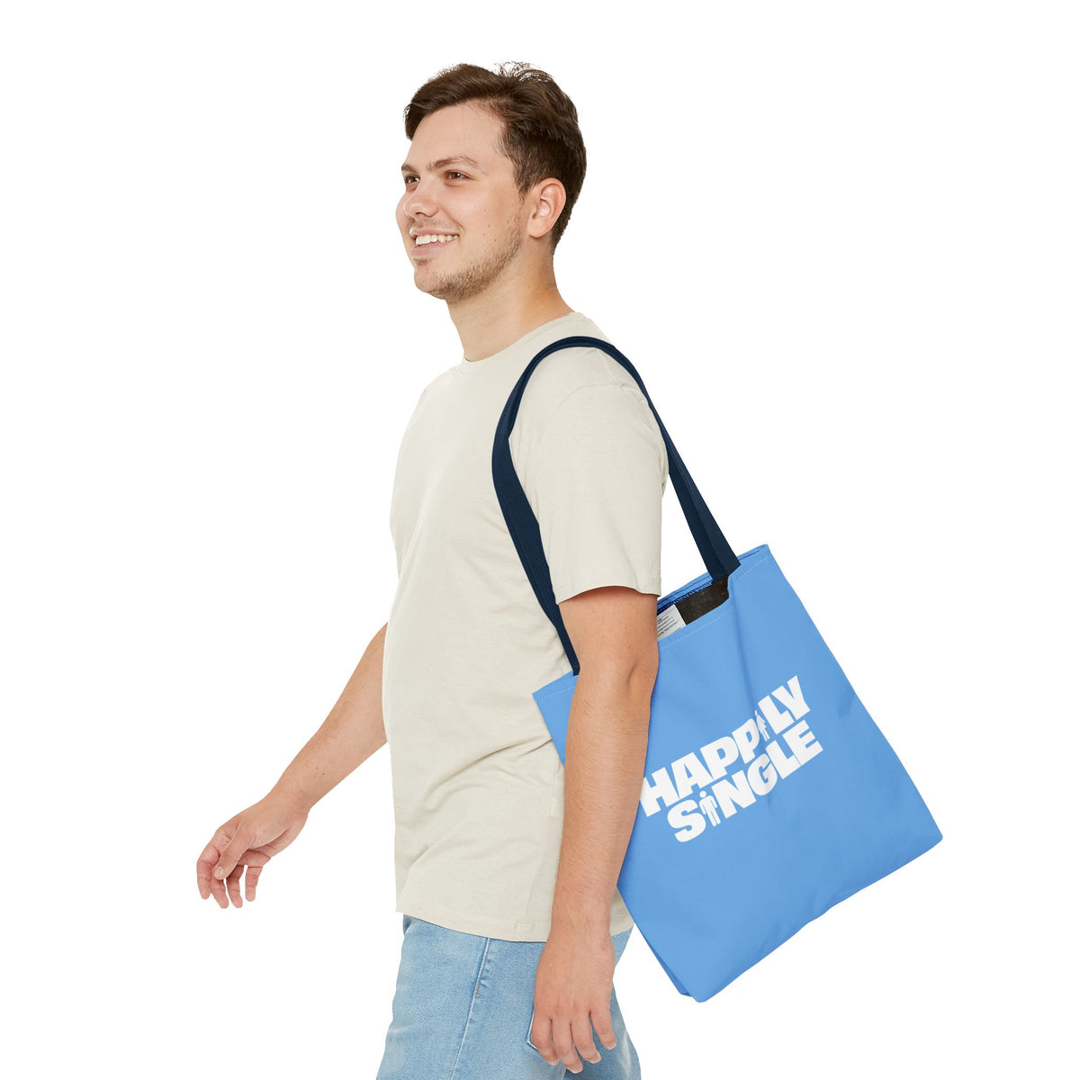 Male model carrying a blue Happily Single tote bag with contrasting navy shoulder straps.