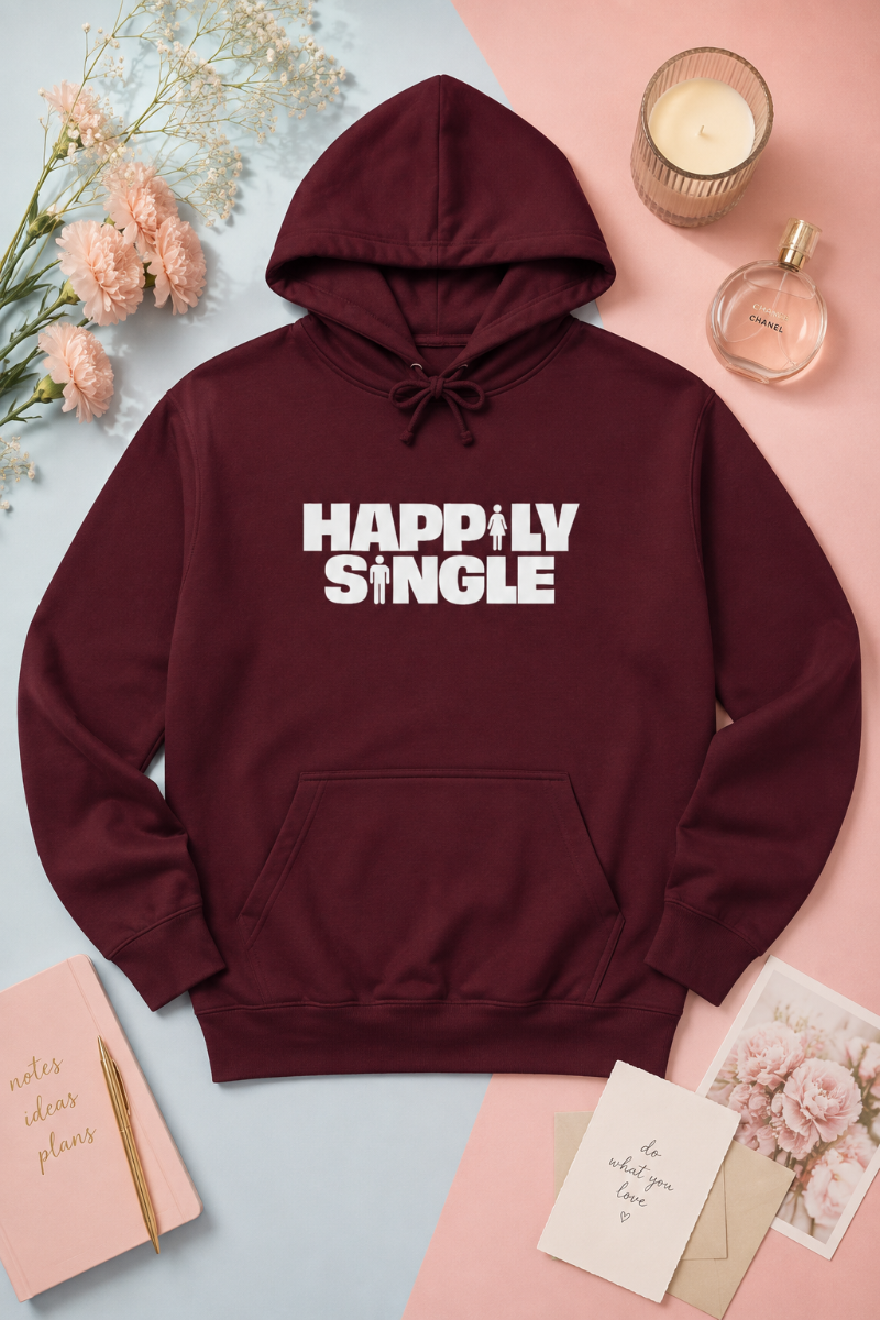 Burgundy Happily Single hoodie flat lay on soft blue and blush pink background