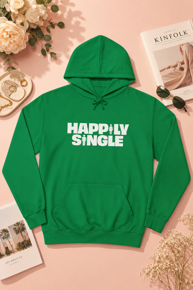 Bright green Happily Single hoodie flat lay on soft peach pastel background