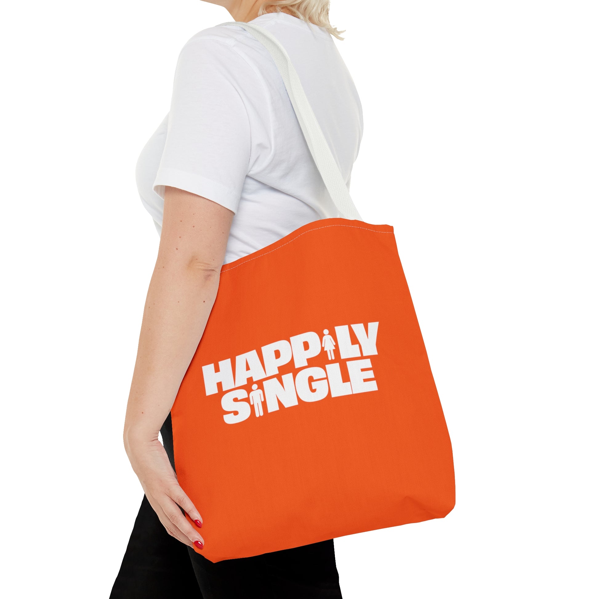 Side view of a person carrying an orange Happily Single tote bag with long white shoulder straps.