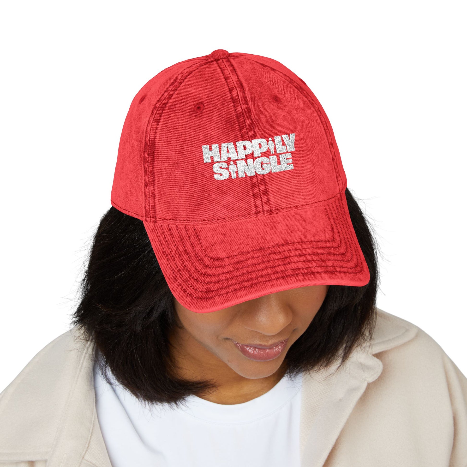 Female model wearing a red Happily Single baseball cap showcasing the embroidered design.
