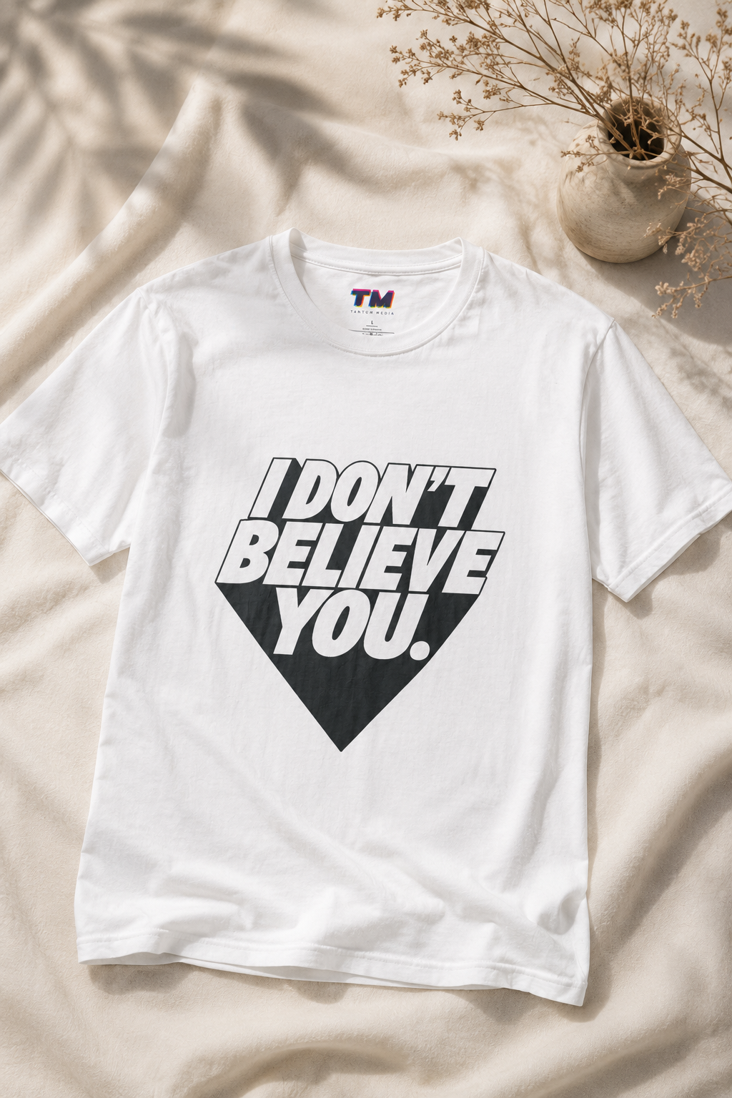 White I Don't Believe You unisex graphic t-shirt displayed on soft fabric in a clean editorial flat-lay presentation.