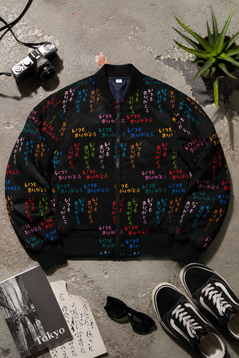 Japanese Street Art Unisex Bomber Jacket flat lay with colorful Japanese lettering on black fabric.