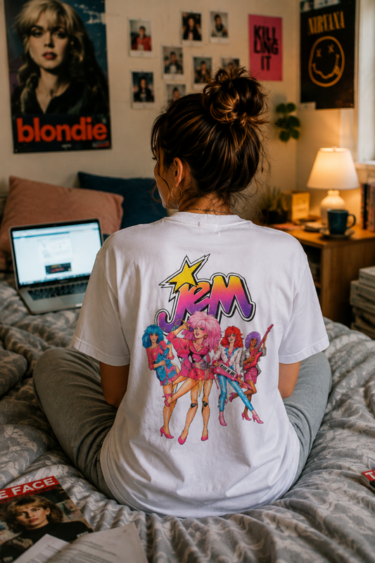 Millennial wearing a white Jem and the Holograms T-shirt indoors with the large retro cartoon graphic visible on the back.