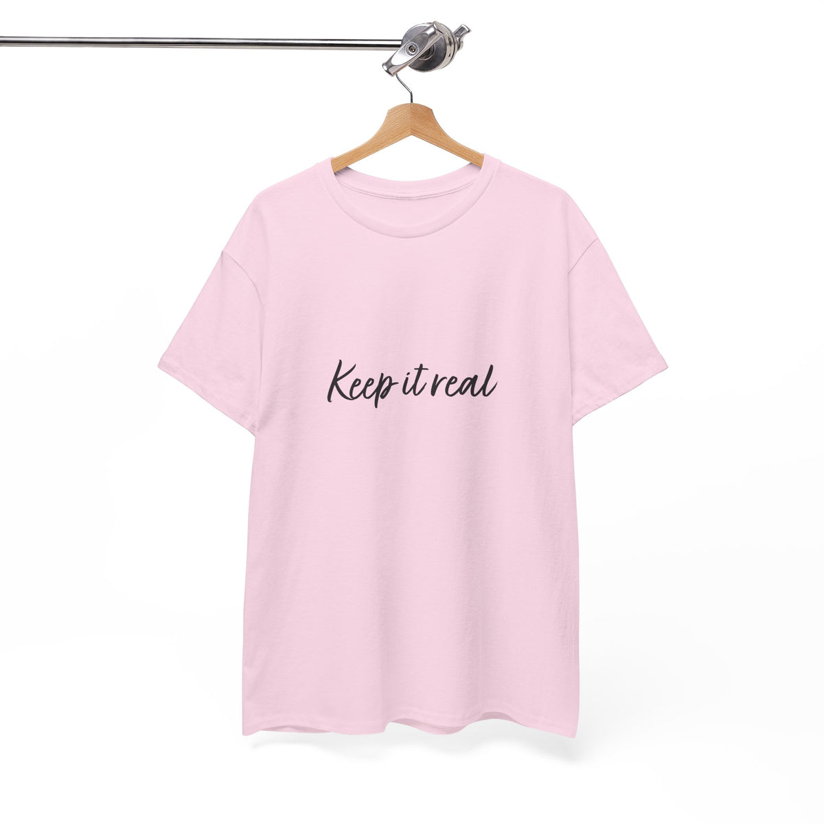 Tantrum Media light pink Keep It Real T-Shirt hanging from a wooden hanger, showing the black script chest print.