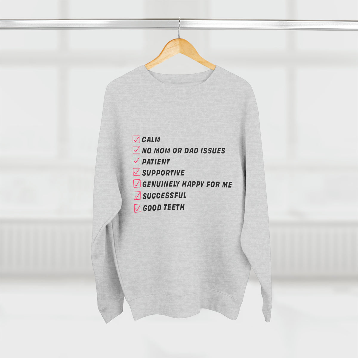 Gray Kim Kardashian’s Men’s Must-Have List crewneck sweatshirt hanging front view with checklist graphic.