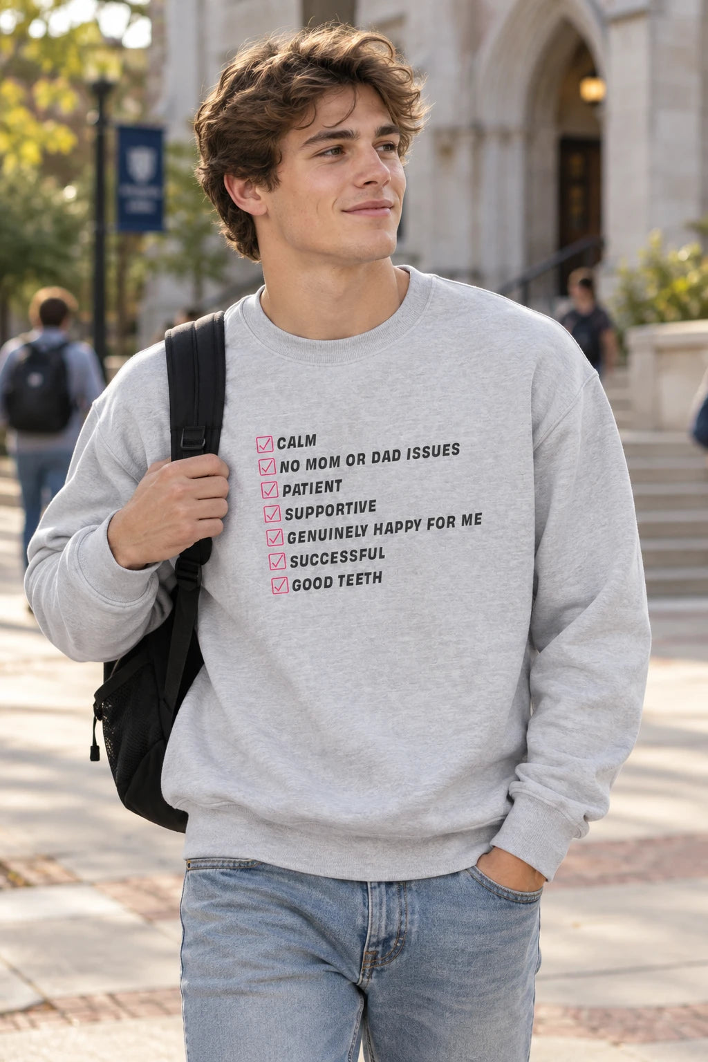 Gray Kim Kardashian’s Men’s Must-Have List crewneck sweatshirt on a young man walking on a campus with a backpack.
