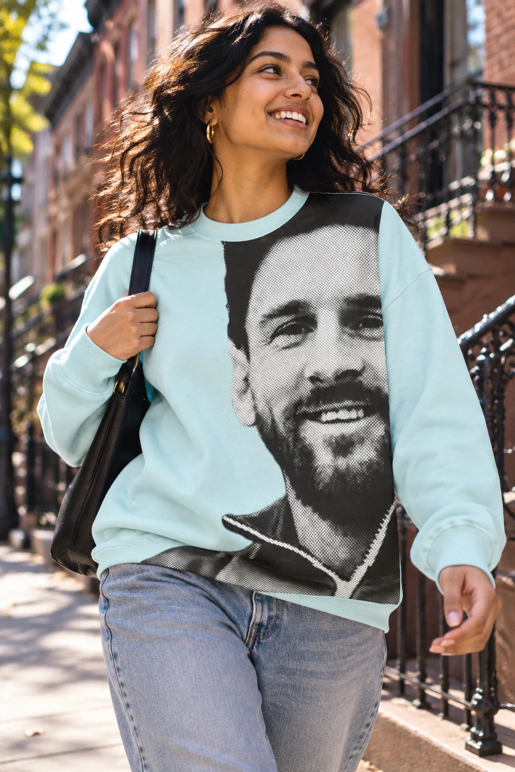 Female wearing light blue Lionel Messi portrait sweatshirt in an urban lifestyle setting