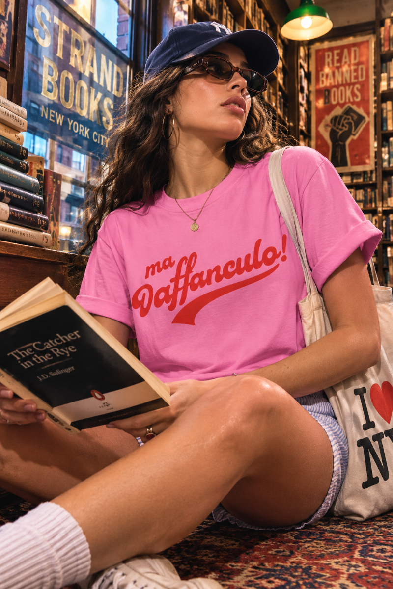 Woman wearing the pink Ma Vaffanculo graphic t-shirt in a vintage New York bookstore.