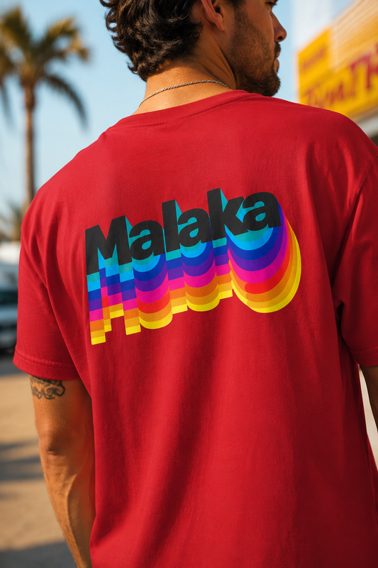 Close-up of a man wearing a red Malaka Greek slang T-shirt with a colorful retro back graphic outdoors