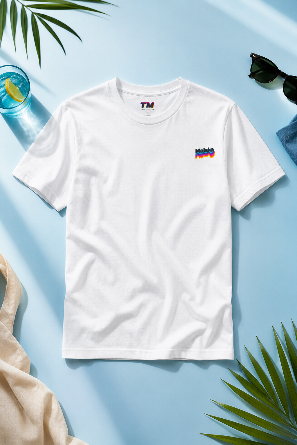 White Malaka Greek slang T-shirt with small chest graphic on a light blue lifestyle flat lay