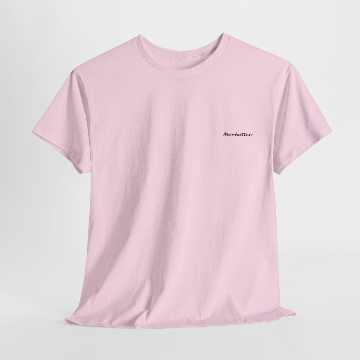 Front view of a pink Manhattan crewneck T-shirt with subtle black cursive lettering on the left chest.