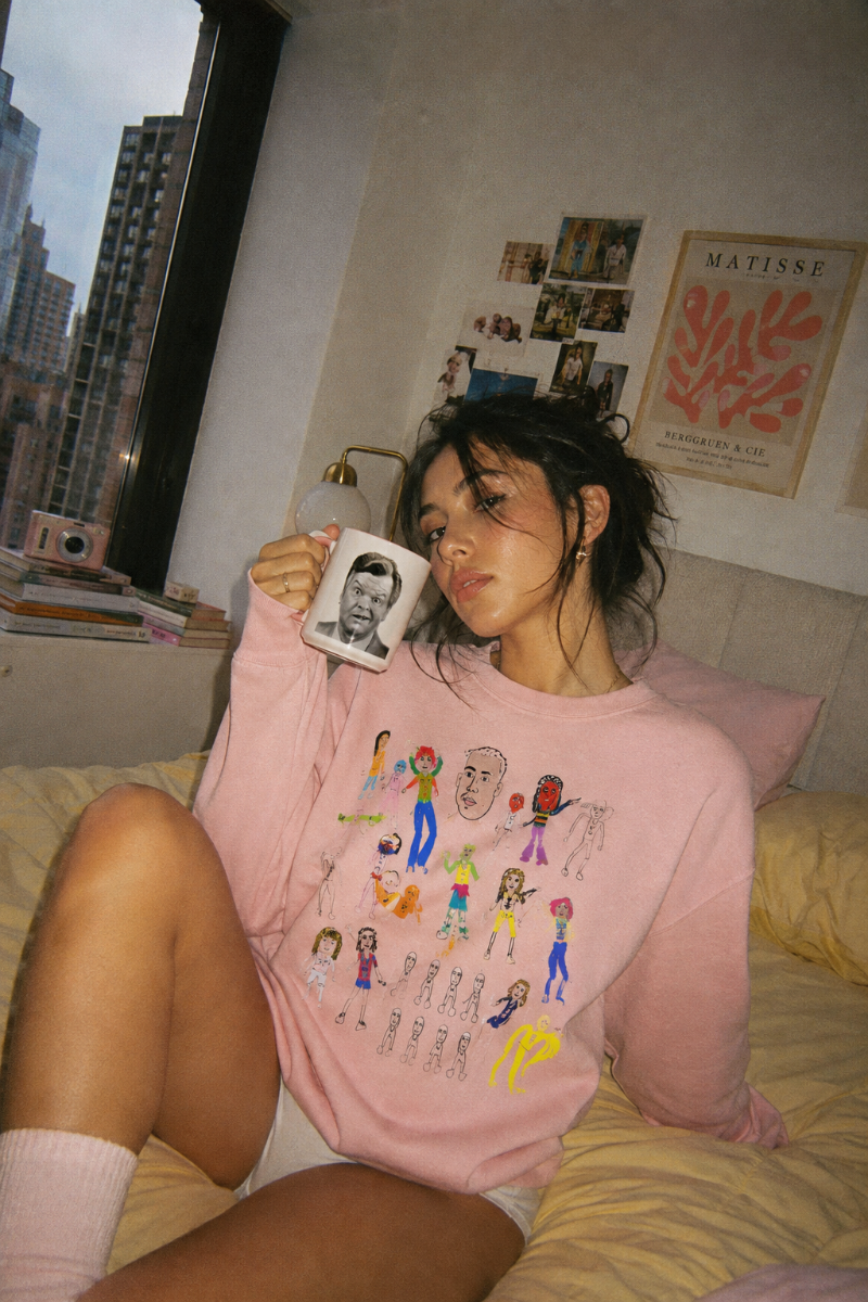 Woman wearing pink Mix Art Crewneck Sweatshirt in a cozy bedroom