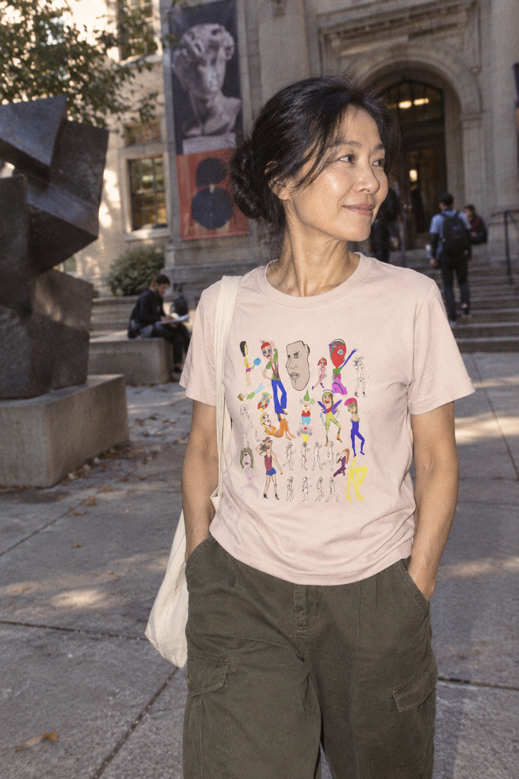 Woman wearing the pale pink Mix hand-drawn art graphic T-shirt in an urban college setting