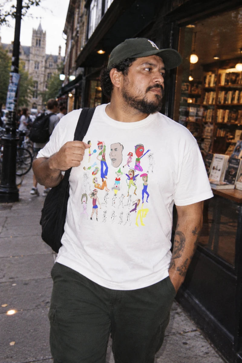 Man wearing the Mix hand-drawn art unisex graphic T-shirt in white in an urban bookstore setting