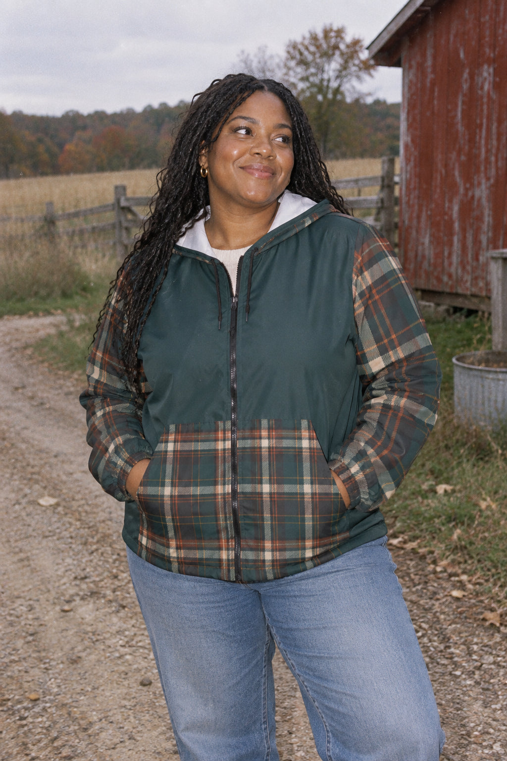 Millennial woman wearing Moss Plaid unisex windbreaker jacket in a rural autumn setting