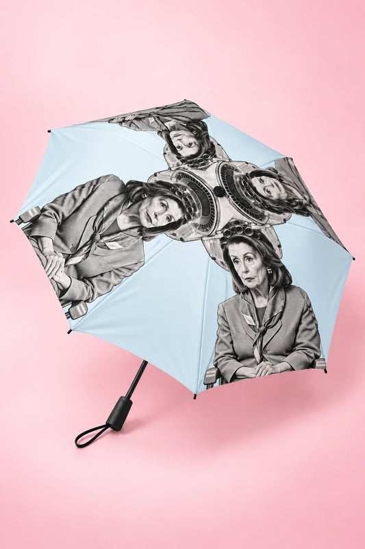 Nancy Pelosi semi-automatic political umbrella in three-quarter view with black shaft and handle on pastel pink background