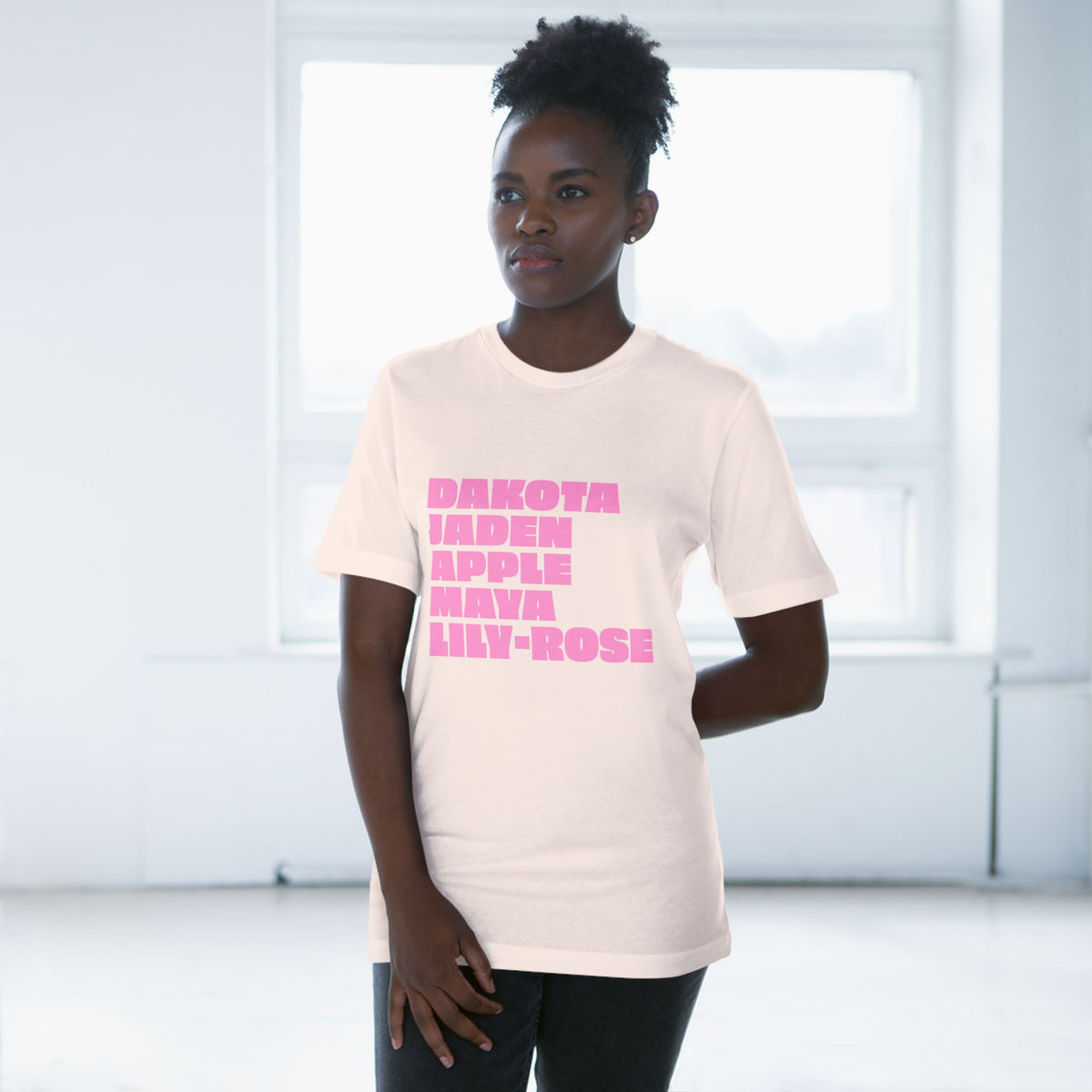 Woman wearing soft pink Nepo Babies List T-shirt