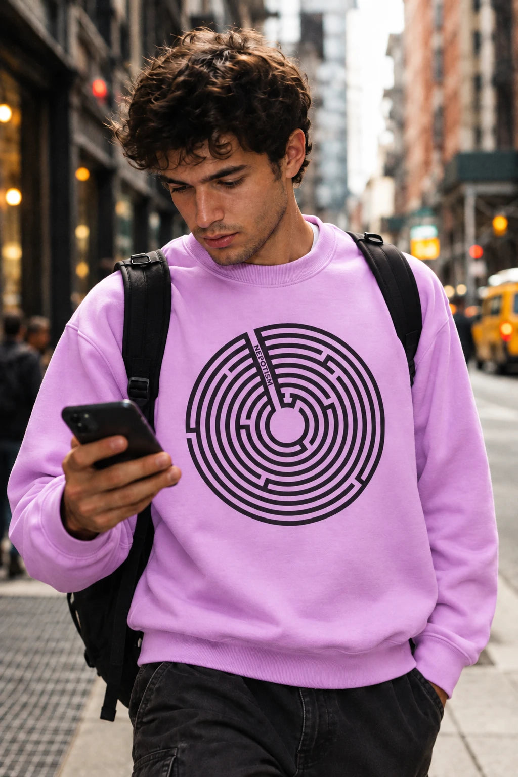 Young man wearing a lavender Nepo anti-nepotism sweatshirt on a New York City street.