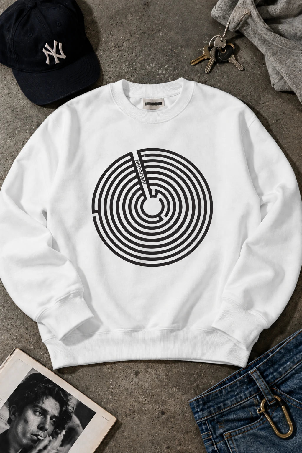 White Nepo sweatshirt with black anti-nepotism maze graphic in editorial flat lay.