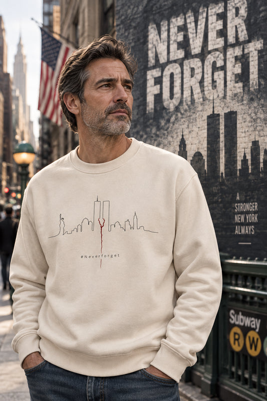 Gen X man wearing cream Never Forget 9/11 sweatshirt in a dramatic New York City lifestyle scene with NEVER FORGET in the background.