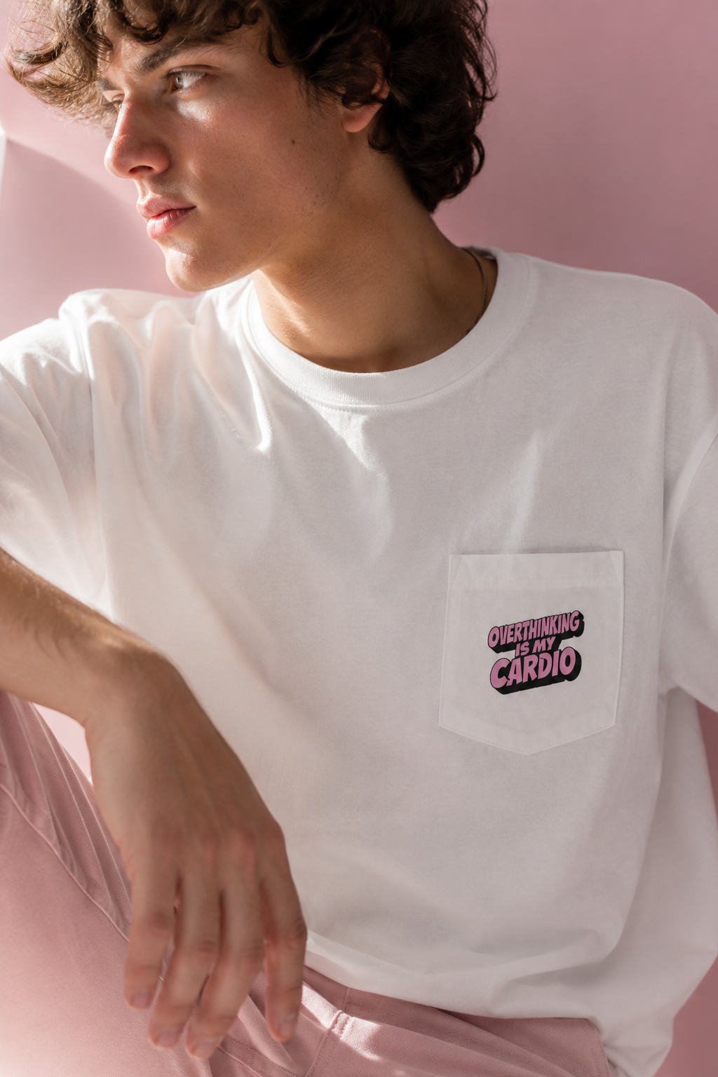 Close-up editorial portrait of model wearing Overthinking Is My Cardio pocket graphic T-shirt front view