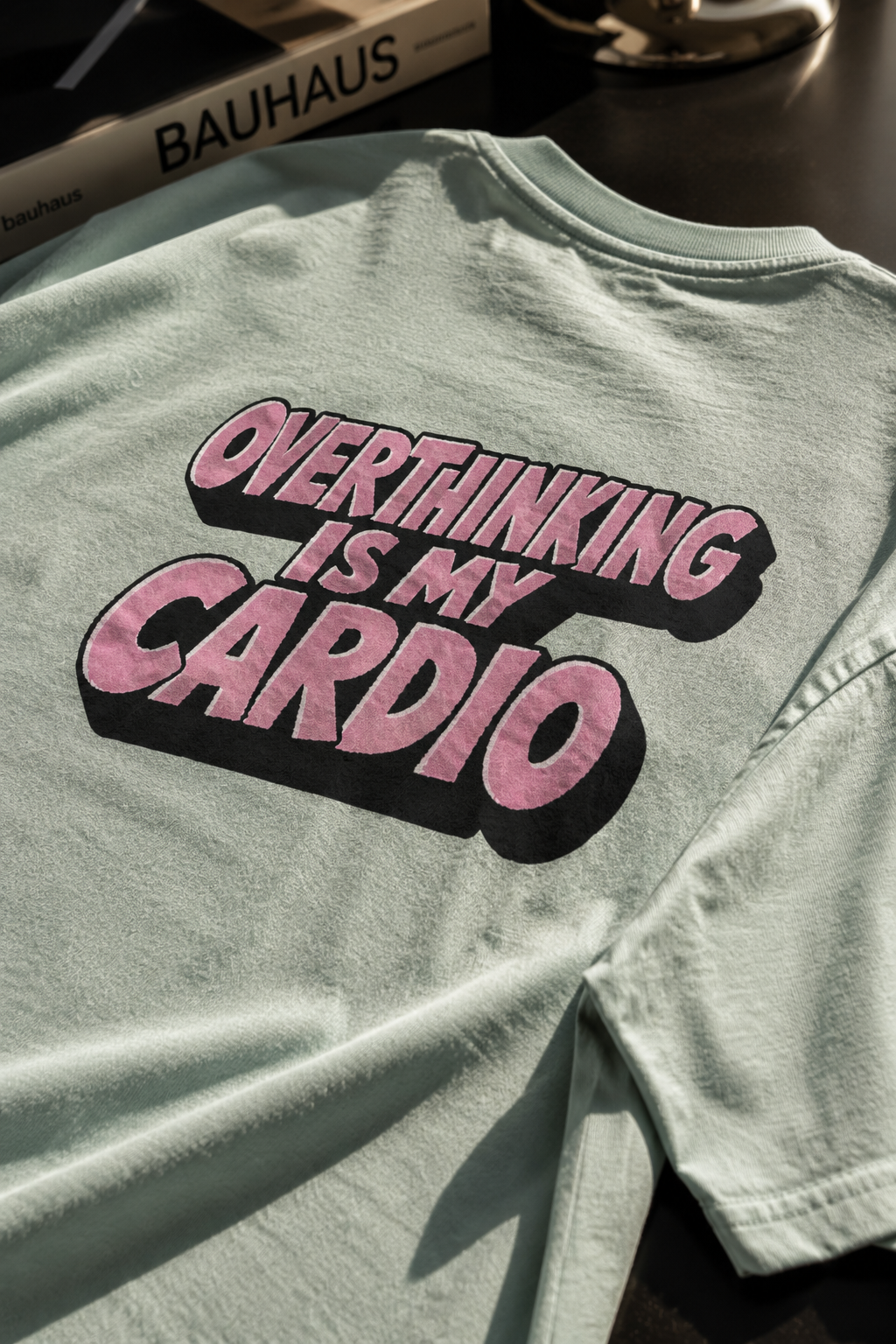 Close-up of sage green Overthinking Is My Cardio graphic showing soft cotton texture