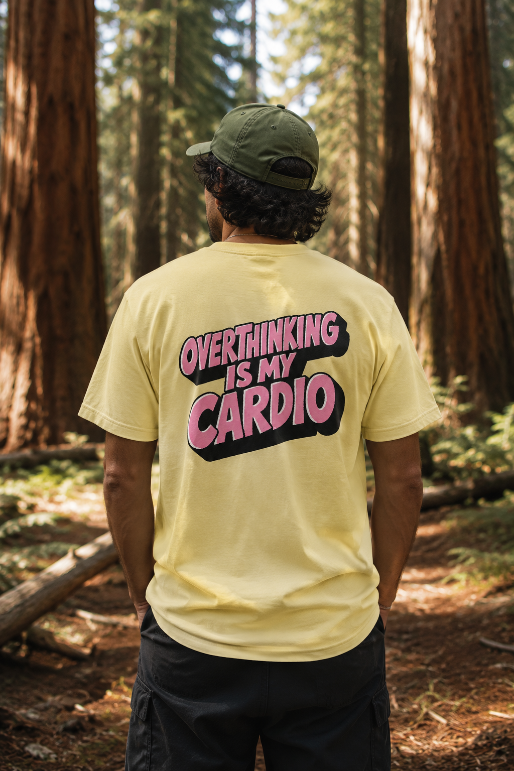 Back view of Overthinking Is My Cardio graphic T-shirt in scenic sequoia forest
