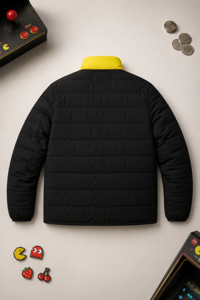Rear flat lay of the black and yellow Pac-Man puffer jacket with retro arcade details.