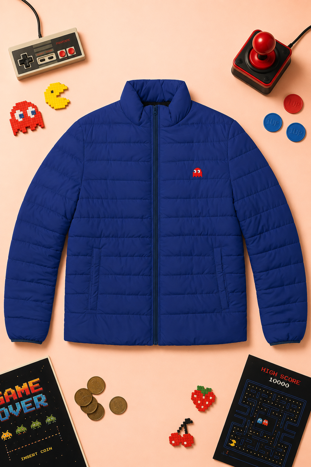 Front flat lay of the Pac-Man Blinky Ghost blue puffer jacket on a soft peach background with retro arcade elements.