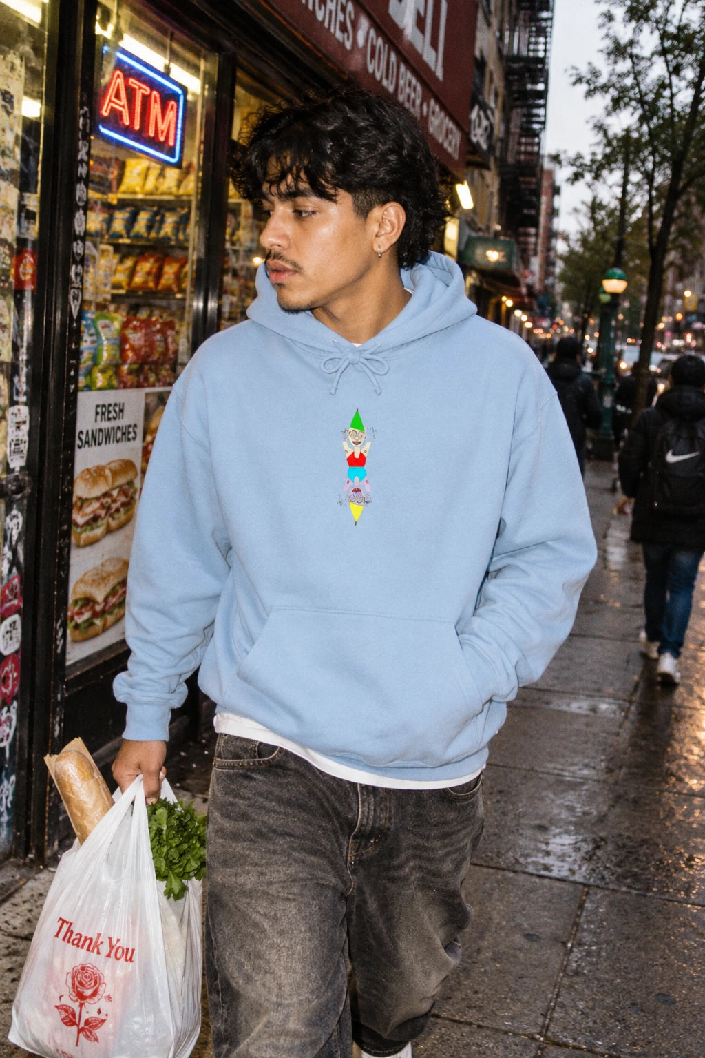 Man wearing the light blue Party Favor graphic hoodie in a NYC street setting