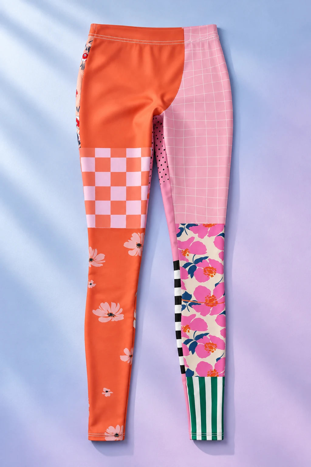 Patchwork Flowers women's leggings laid flat on a soft blue background, showing contrasting floral and geometric prints.