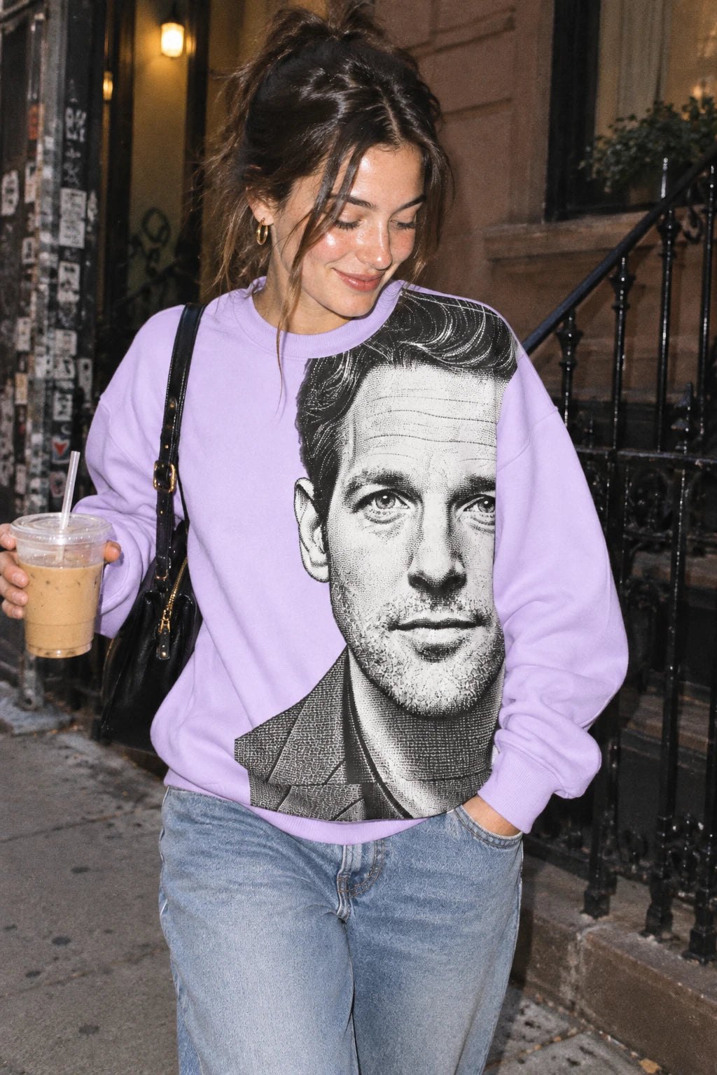 Woman wearing lavender Paul Rudd portrait sweatshirt in a candid urban street setting