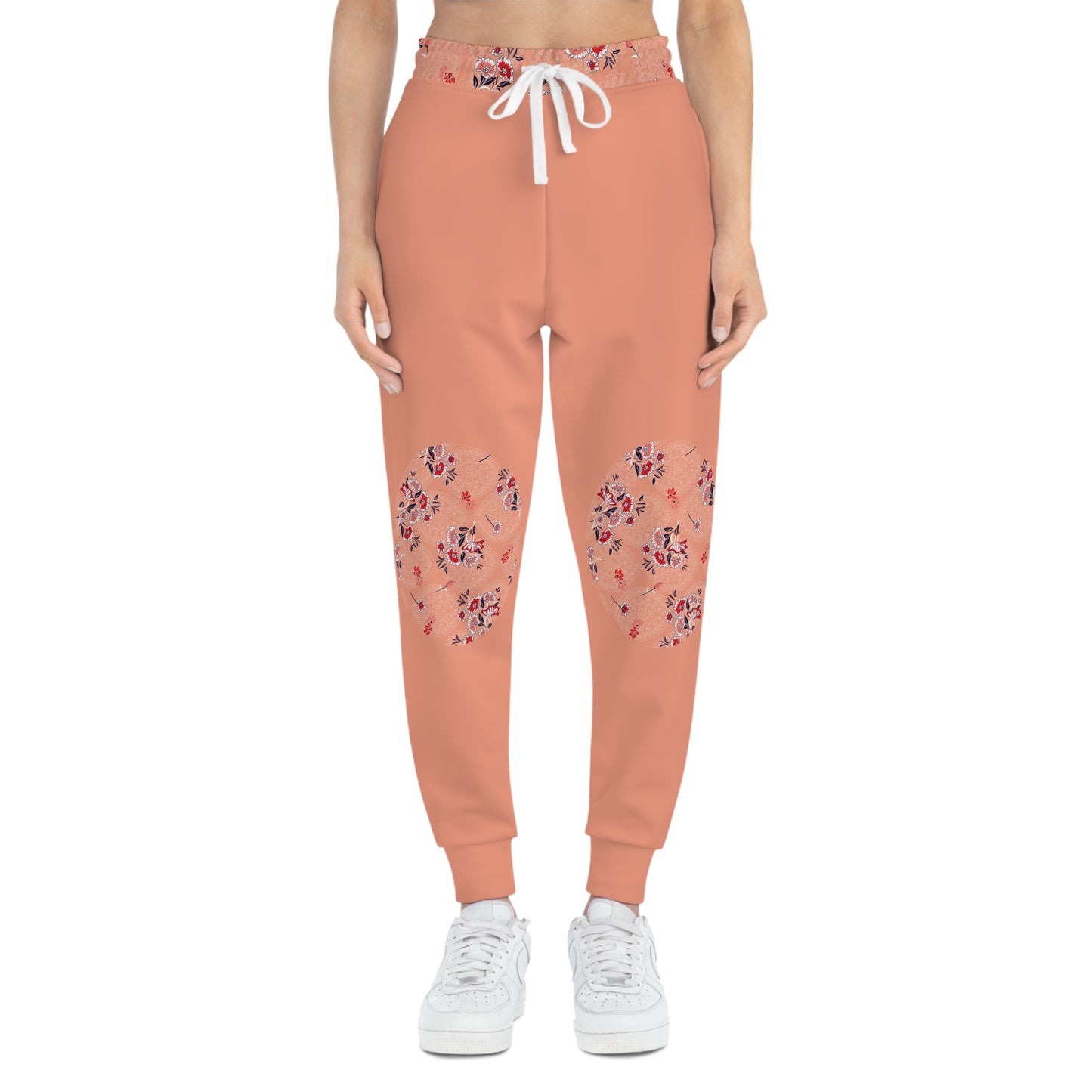 Model wearing peach floral joggers with decorative floral knee patches