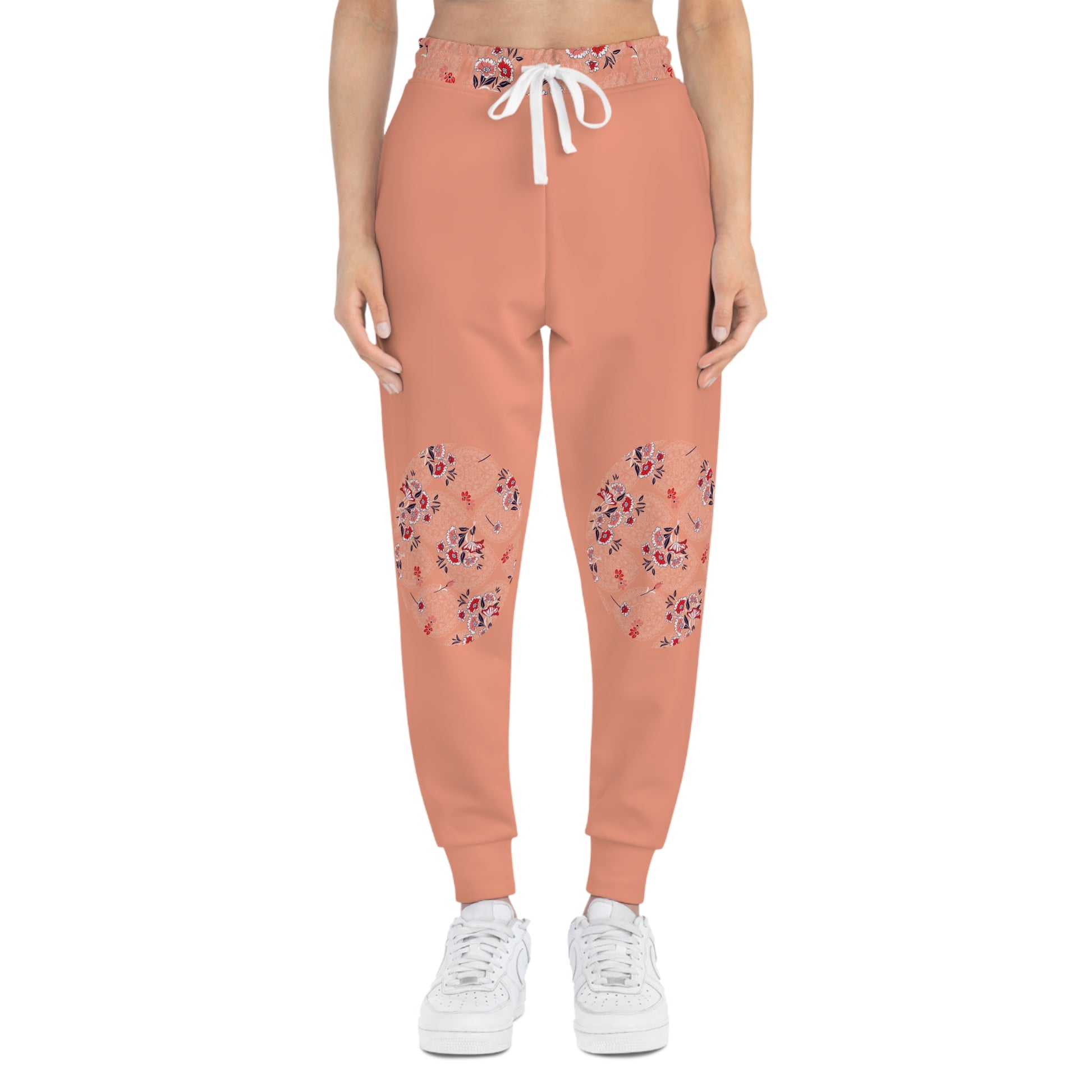Model wearing peach floral joggers with decorative floral knee patches