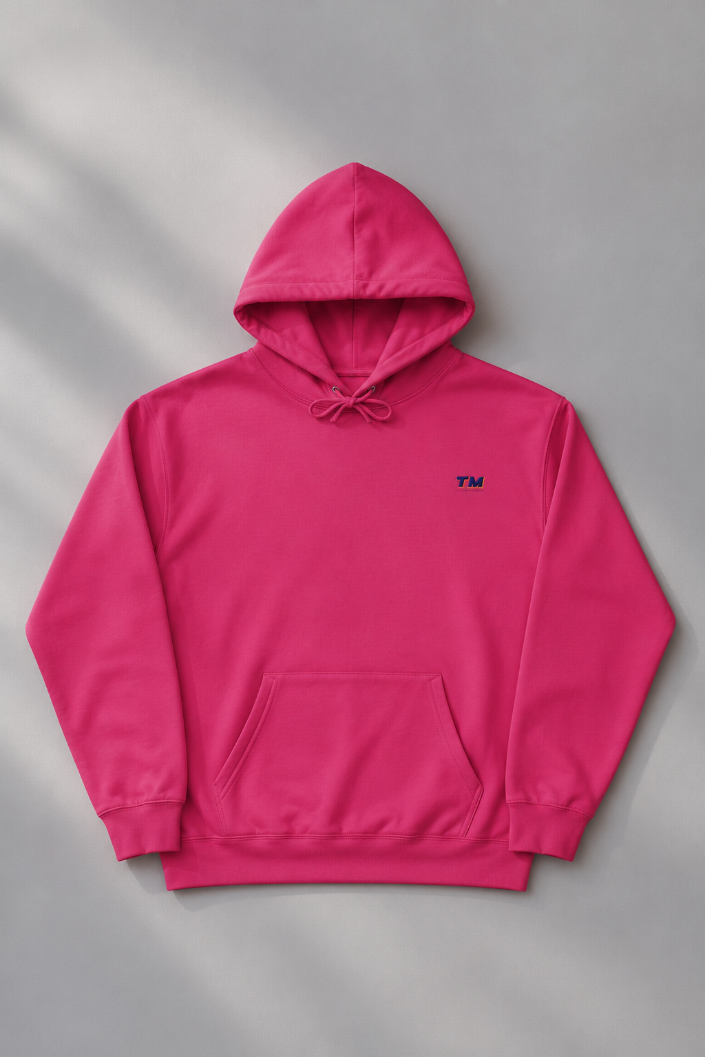 Tantrum Media EcoSmart pink hoodie flat lay on a soft pastel background.
