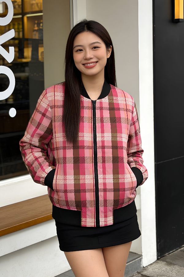 Woman wearing a pink plaid women’s bomber jacket in a casual urban setting