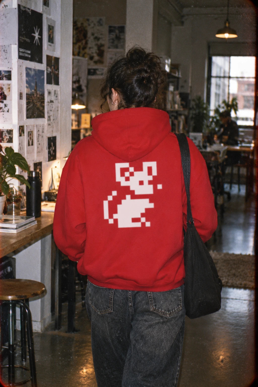 Red Pixel Mouse Zip Hoodie worn from the back in creative studio setting