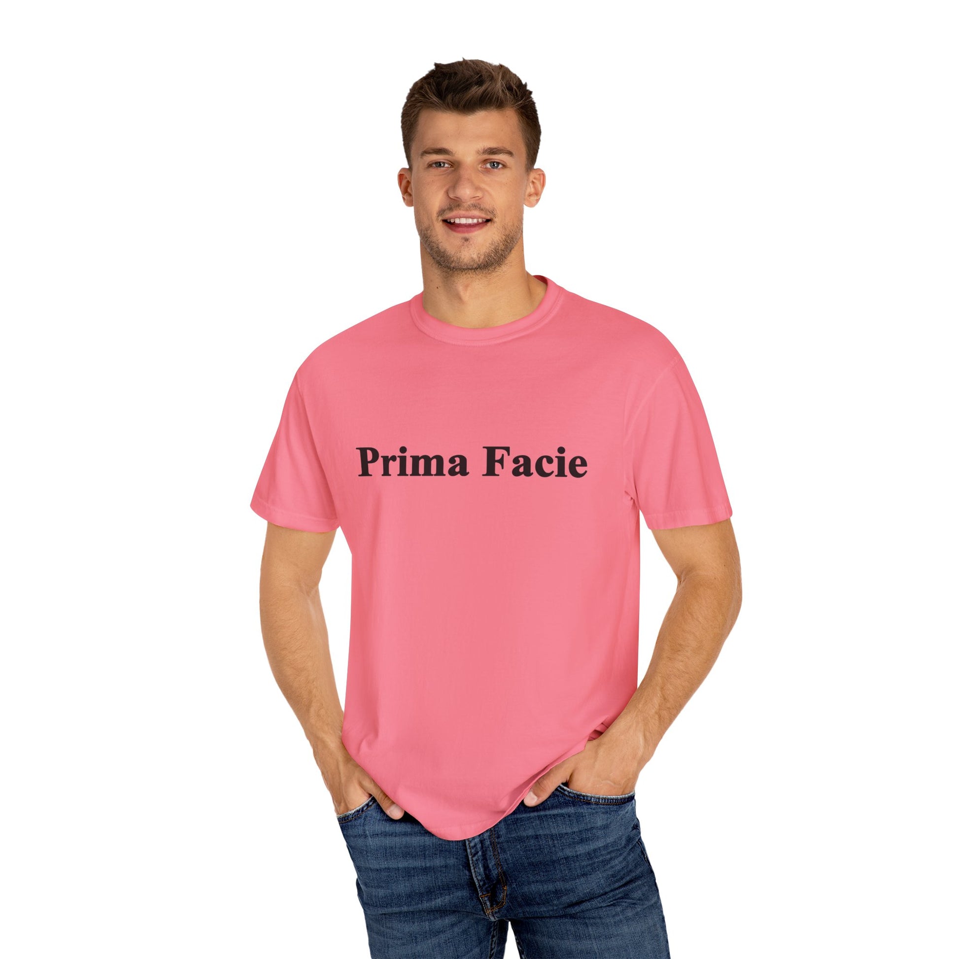 Young male model wearing a bright pink Prima Facie unisex graphic T-shirt in a clean studio portrait.