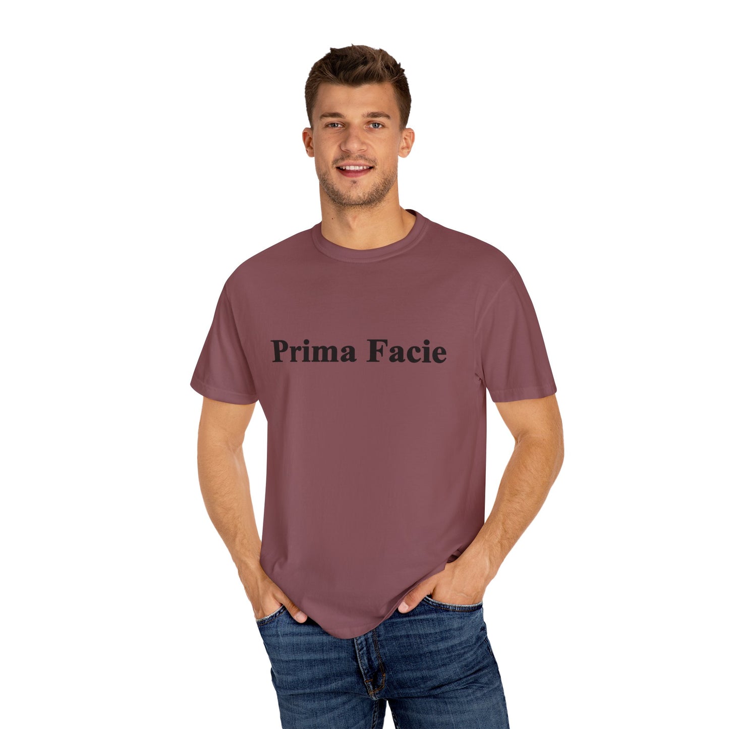 Young male model wearing a burgundy Prima Facie unisex graphic T-shirt against a neutral studio background.