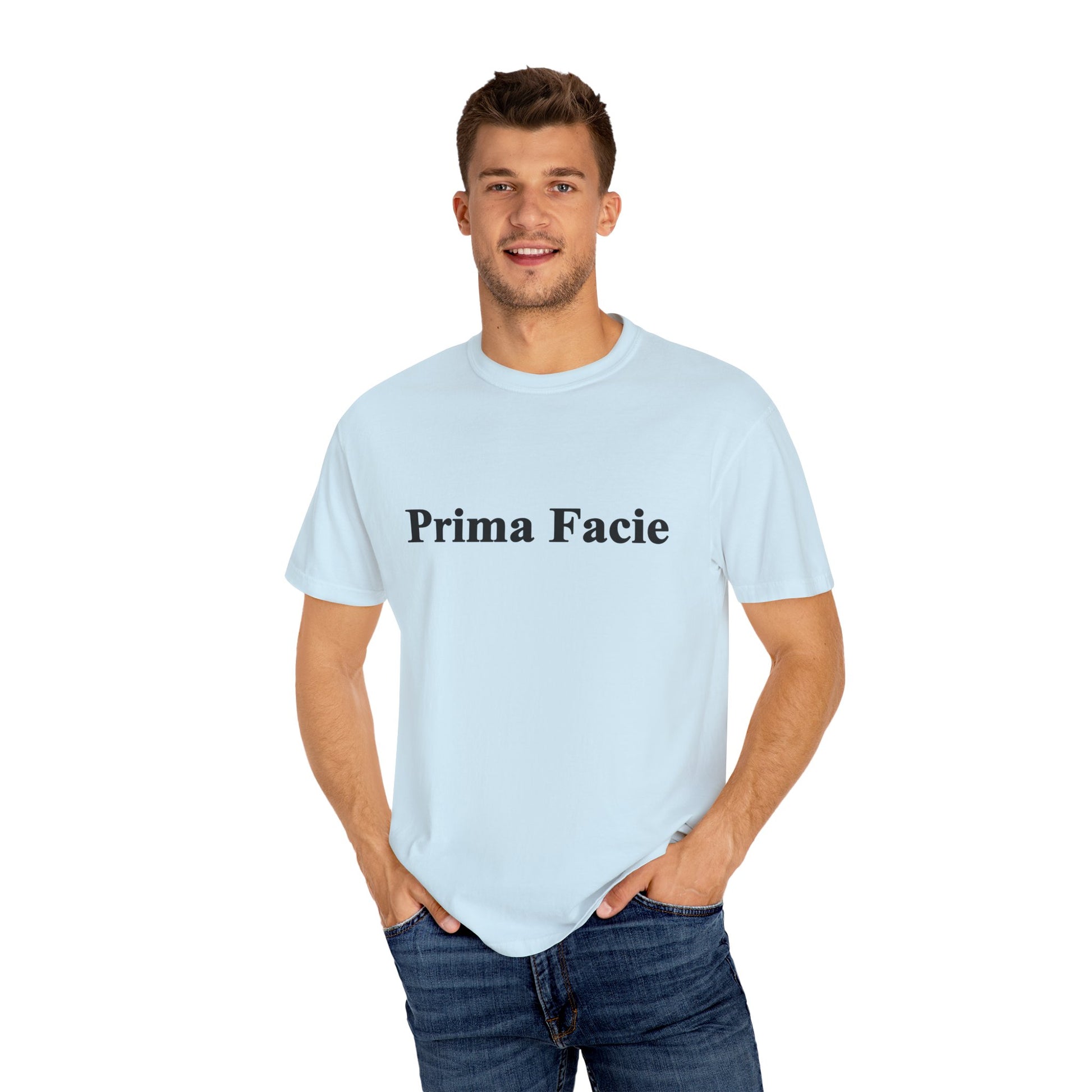Young male model wearing a light blue Prima Facie unisex graphic T-shirt against a bright studio background.